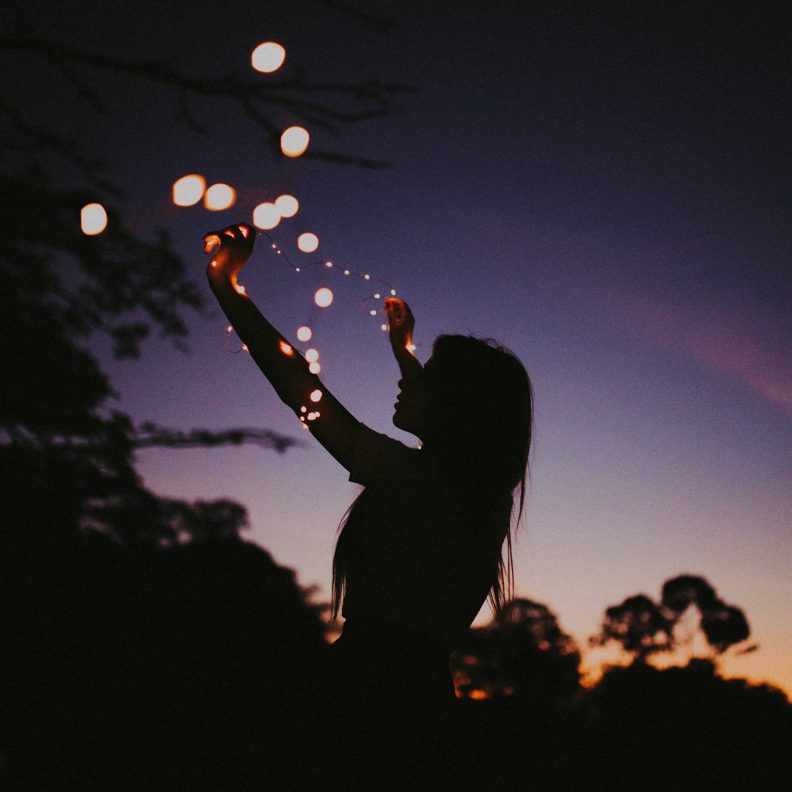 Silhouette photo of woman holding lights 3792581